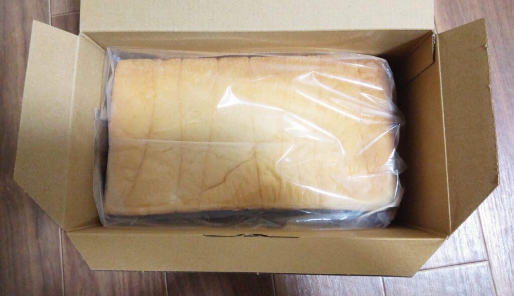 LeTAO（ルタオ）の北海道生クリーム食パンが入った箱の蓋を開ける写真