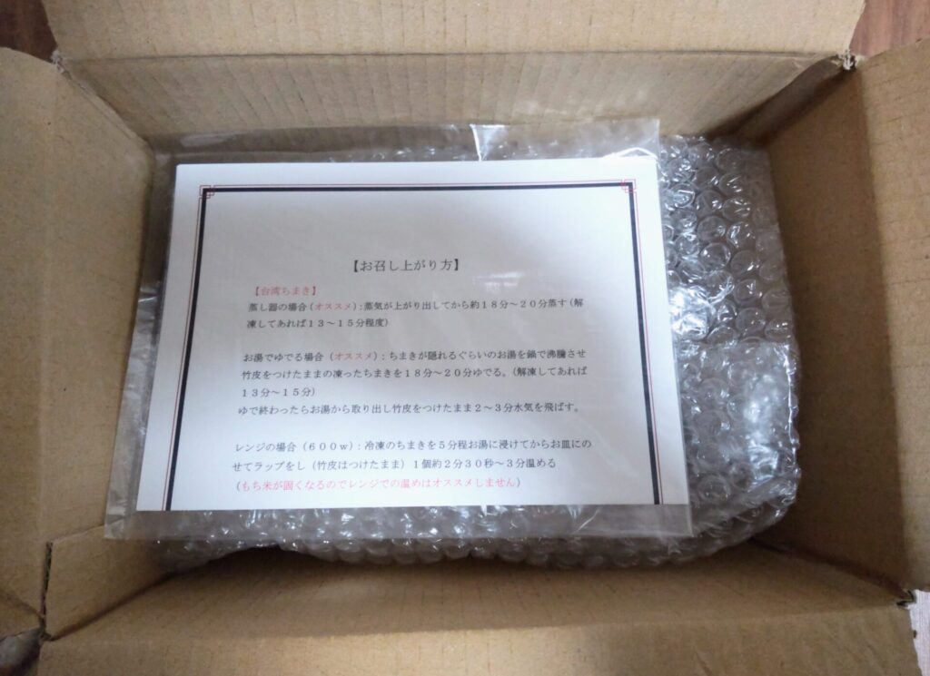 兵庫県西脇市のふるさと納税返礼品手作り台湾ちまき5個セットにお召し上がり方が書かれた紙が添えられていたことがわかる写真