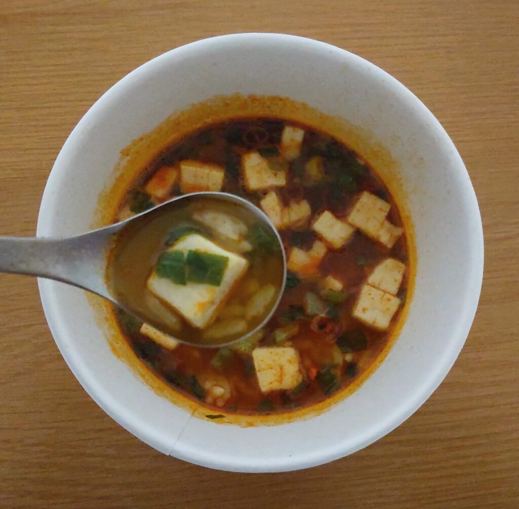 完成したbibigoのレンジdeクッパ海鮮スンドゥブの豆腐をスプーンですくった写真